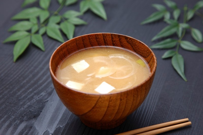 Wooden bowl full of miso soup.