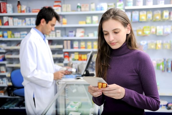 Lady in pharmacy holding pills
