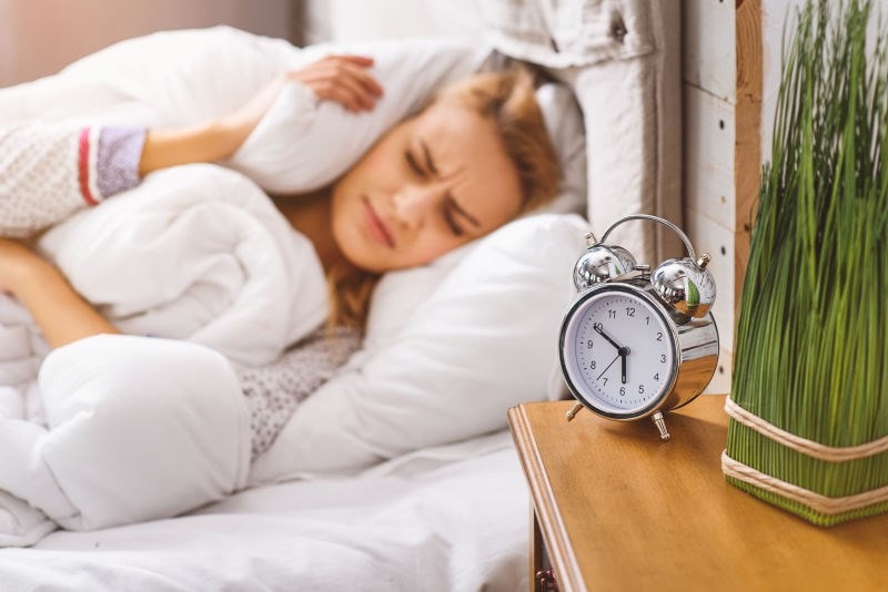 woman distressed listening to alarm clock