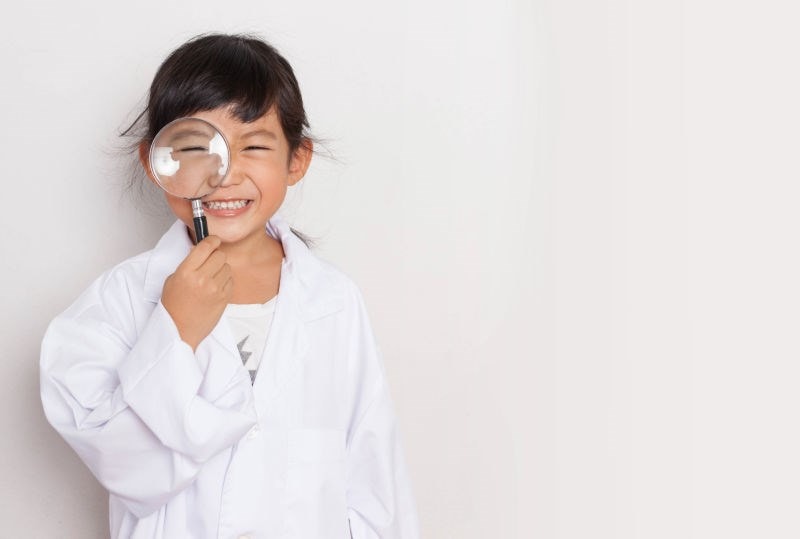 child holding magnifying glass