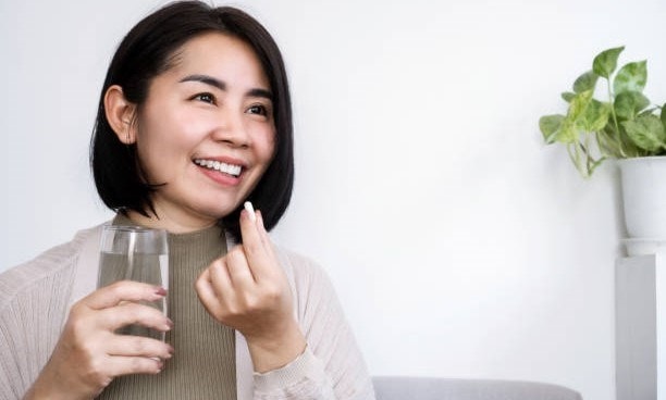 Image of woman taking a supplement