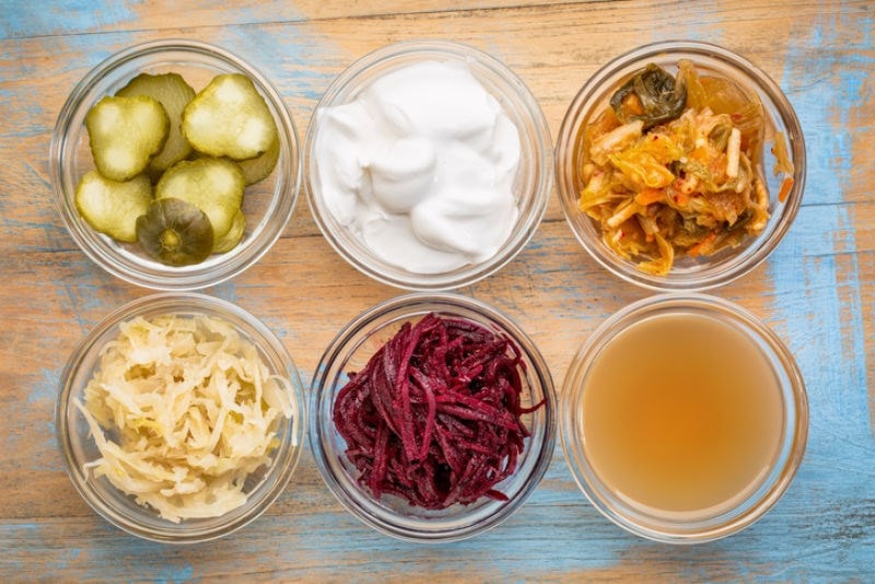 Six little bowls of various fermented foods.
