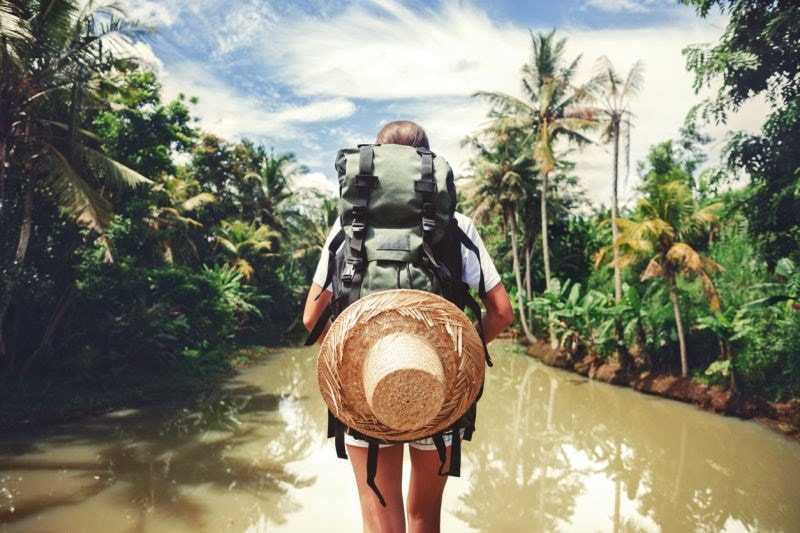 backpacker walking through rainforest water
